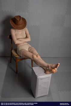 a woman sitting in a chair with her legs crossed and wearing a hat on top of her head