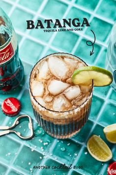 an image of a drink in a glass with ice and limes next to it