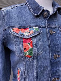 a denim jacket with colorful flowers on it