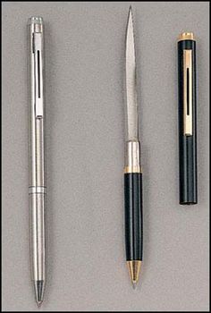 three different types of pens on a gray surface with one pen in the middle, and two