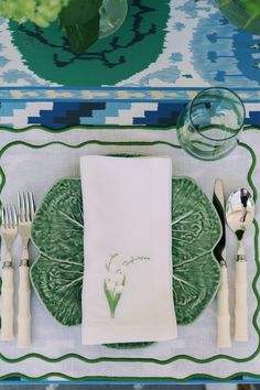 a place setting with green plates and silverware