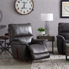 a living room with two recliners and a clock on the wall behind them