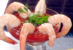 a glass bowl filled with shrimp and garnish