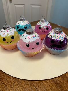 five cupcakes with sprinkles on them sitting on a table