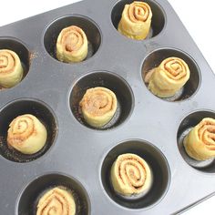 twelve cinnamon rolls in a muffin tin ready to be baked