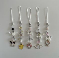 several charms are hanging on a white surface