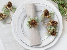 a place setting with pine cones and greenery on the napkins, along with other holiday decorations