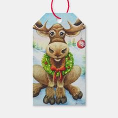 a christmas gift tag with a moose wearing a wreath on it's neck and an ornament hanging from the front