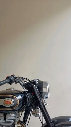 a black motorcycle parked in a room next to a wall