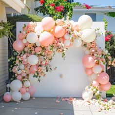 a bunch of balloons that are in the air and some flowers on the ground next to it