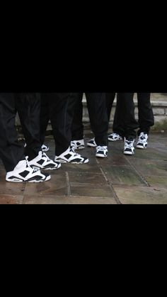 a group of people standing next to each other wearing black and white shoes