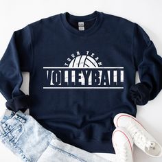 a sweatshirt that says your team volleyball with a ball in the center and two pairs of jeans next to it