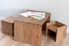 a wooden table with two chairs next to it and papers on the table top in front of them