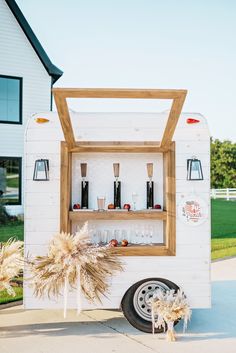 a white trailer with shelves filled with bottles and glasses