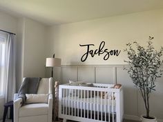 a baby's room with a white crib and a tree in the corner