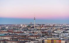 an aerial view of a city with tall buildings in the foreground and a pink sky