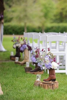 rows of white chairs with purple flowers in them on the grass at a wedding ceremony