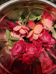 some red flowers are in a silver bowl