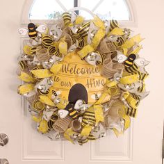 a welcome to our hives wreath on the front door with bees and honeycombs