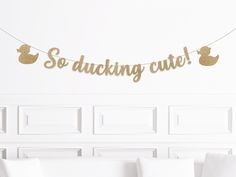 a gold foil ducky banner hanging from a string