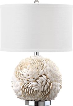 a table lamp with a white flower on the base and a light shade over it