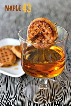 a glass filled with liquid next to cookies