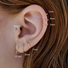 an ear with three different types of piercings on the top and bottom of it