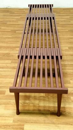 a wooden bench sitting on top of a hard wood floor