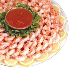 a platter with shrimp and lettuce on it, sauce in the middle