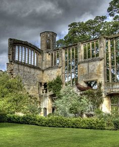 an old building with ivy growing on the outside and windows in the middle, surrounded by trees