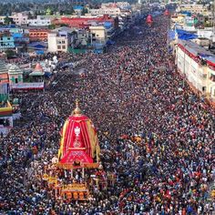 an aerial view of a large crowd gathered around a shrine in the middle of a city