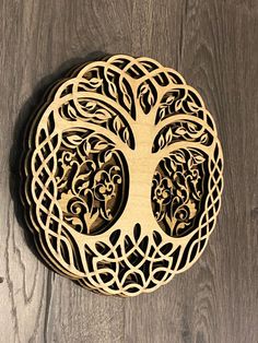 an intricately designed wooden clock with a tree on it