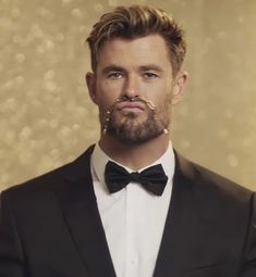 a man in a tuxedo with piercings on his nose