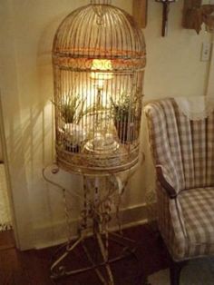 a bird cage sitting on top of a table next to a chair