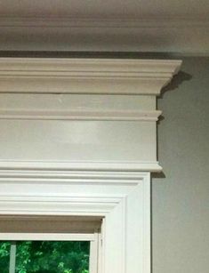 the corner of a window in a room with white trim and molding on it