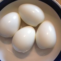 four white eggs in a blue and white bowl