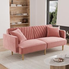 a pink velvet couch in front of a fireplace