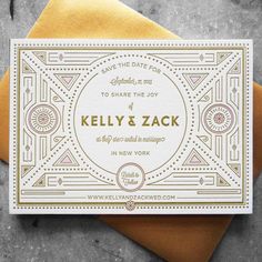 an art deco wedding save the date card on top of a yellow envelope with gold foil