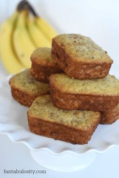 a white plate topped with banana muffins next to a bunch of bananas