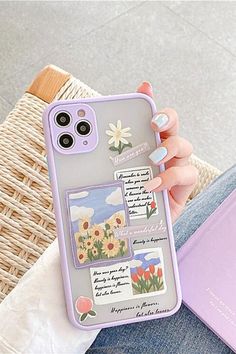 a woman is holding up her phone case with flowers on it and some stickers