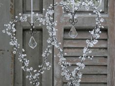 two heart shaped glass ornaments hanging from the side of a door