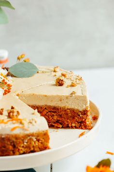 a white plate topped with a cake covered in frosting next to a potted plant