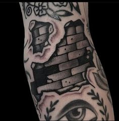 a man's arm with tattoos on it and an eye in the middle of his arm