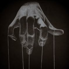 a drawing of a hand reaching out from the ground, with strings attached to it