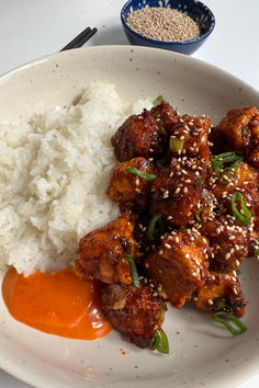 a white plate topped with meat and rice