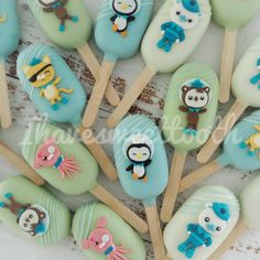 there are many decorated cake pops on the stick with animals and fish in them, as well as some other decorations