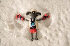 a toy sheep is standing in the snow