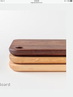 two wooden cutting boards sitting on top of each other