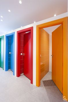 an empty room with multiple colored doors