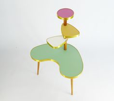 a table with three different colored tables on it's legs and one is shaped like a flower